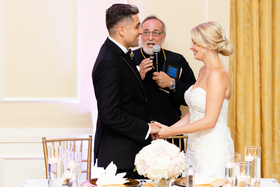 priest praying over the couple