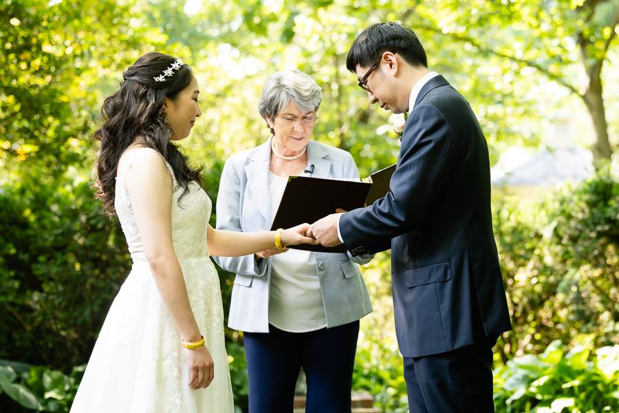 groom placing the ring on the bride