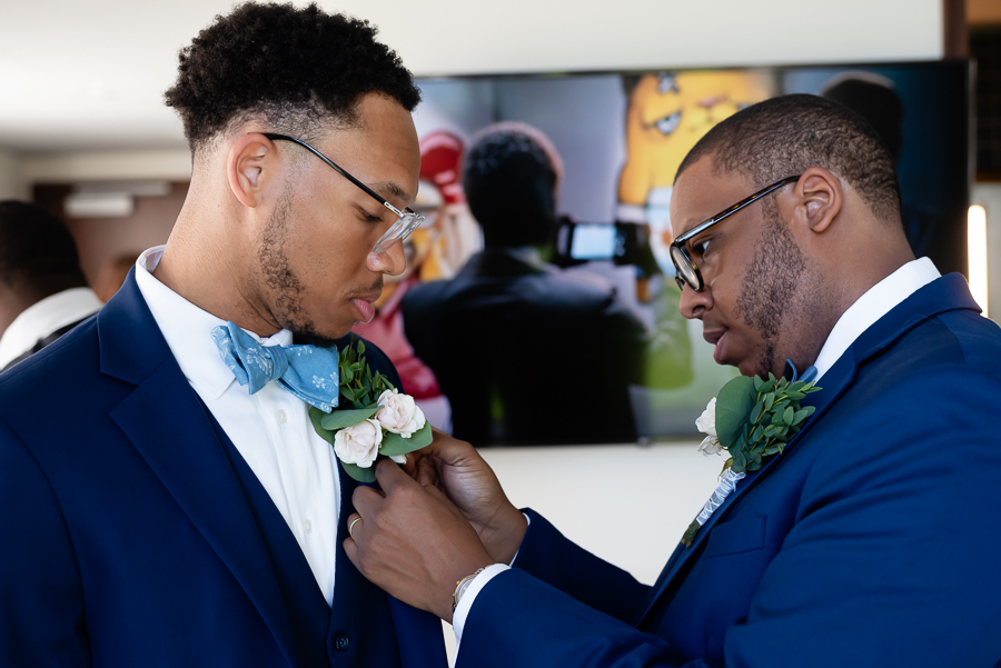 boutonniere adjusted by the groom's brother