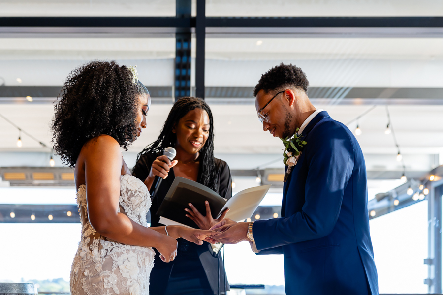 groom placing the ring on the brides finger