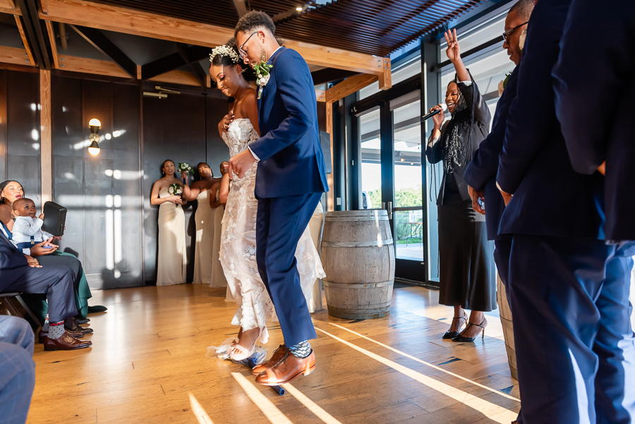 bride and groom jump the broom at district winery
