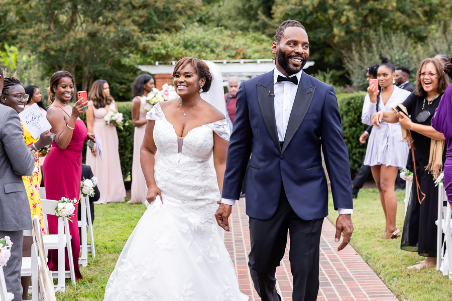 Couple walking hand in hand through the gardens.